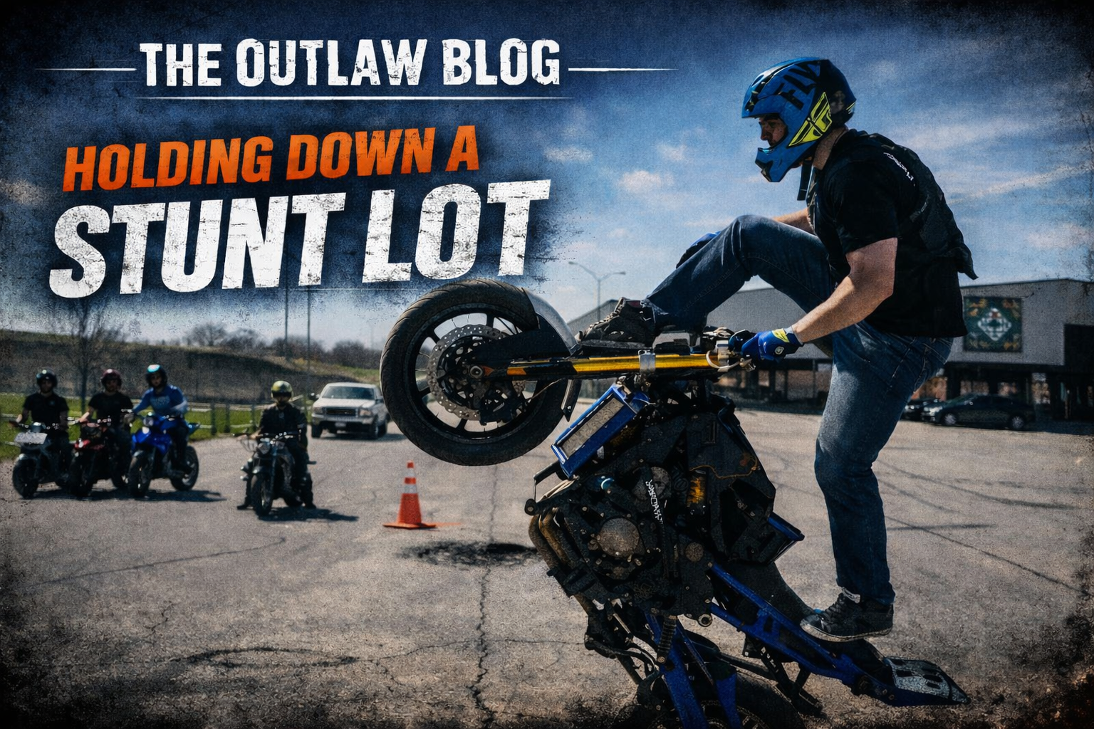 Motorcycle stunt rider practicing wheelies in an industrial parking lot during a private stunt session